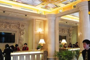 A lobby with marble columns, a reception desk, a television, and a chandelier. - Wuhu Garden Lake View Hotel (Zhongshan Road Pedestrian Street) (Wuhu)