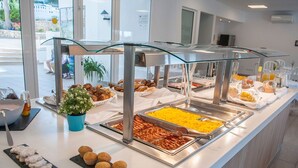 Un bufé con diversos alimentos, como pasteles, carnes y frutas.