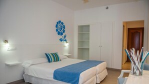 Un dormitorio con cama, mesitas de noche, un armario y una puerta que da a otra habitación.