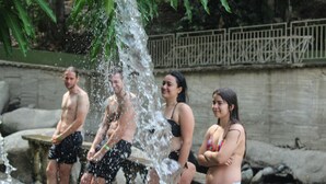 A group of people standing by a water feature in an outdoor setting. - Hostería Río Escondido (San Jerónimo)