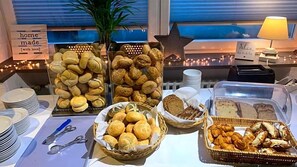 A buffet table with various baked goods, including bread, pastries, and cookies.