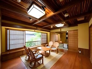 Habitació japonesa tradicional amb tatami, una taula baixa i mobles de fusta.