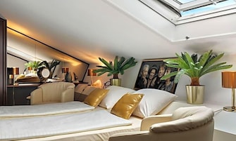 Ein Schlafzimmer mit einem Bett, Nachttischen, Lampen und Topfpflanzen.