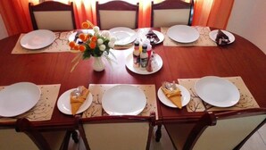 A dining table set for eight with plates, cutlery, and condiments. - Rest Shade Bed And Breakfast (Palapye)