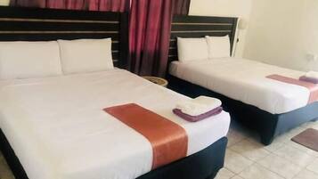 Two single beds with white linens and brown headboards in a hotel room.