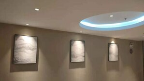 A hallway with three framed artworks on the wall, recessed lighting, and a circular ceiling light. - Home Inn (Pizhou Jiefang East Road) (Pizhou)