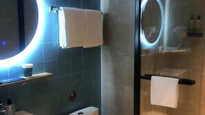 A modern bathroom with a glass shower enclosure, a round mirror, and a white sink. - Home Inn (Pizhou Jiefang East Road) (Pizhou)