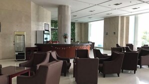 A spacious lobby with a reception desk, several seating areas, and large windows allowing natural light. - Uchoice Hotel (Jiexi)