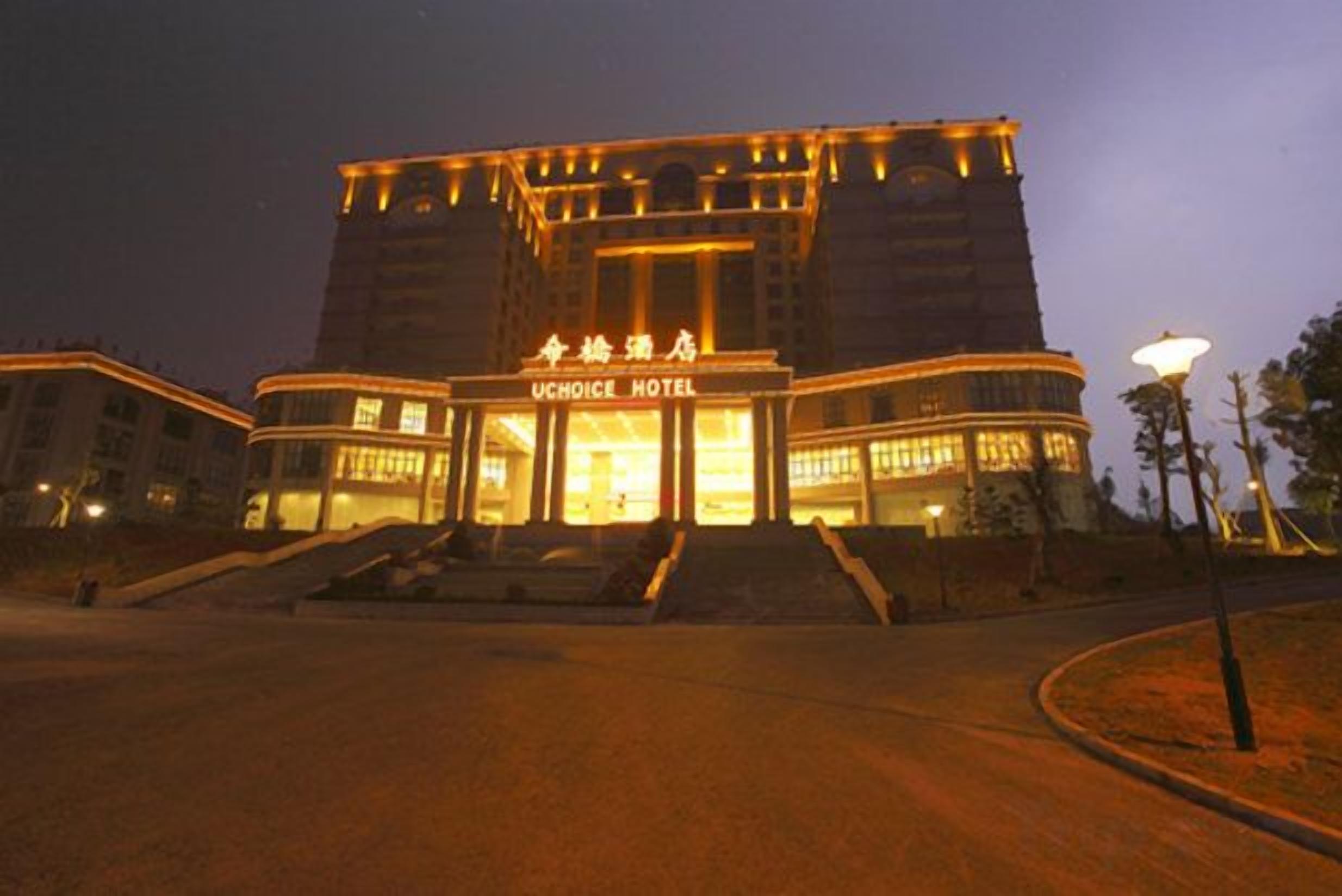 A hotel with a prominent entrance, a large sign, and a well-lit facade.
