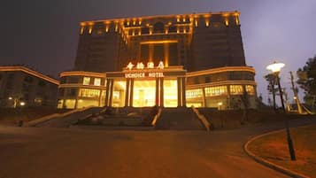 A hotel with a prominent entrance, a large sign, and a well-lit facade.