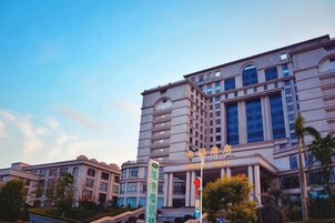Un hotel de varios pisos con un diseño arquitectónico clásico, que cuenta con grandes ventanales y una entrada destacada.