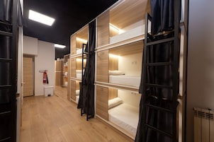 Ein Hotelzimmer mit Etagenbetten, Holzböden und einem Feuerlöscher.