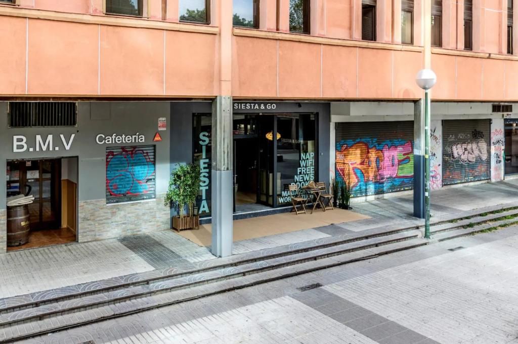 A building with a storefront labeled 'B.M.V' and 'Cafetería' with a closed shutter.
