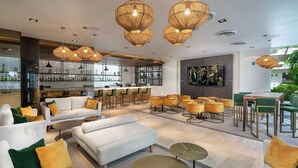 A modern lounge area with sofas, tables, and a bar. - Antera Hotel & Residences (Playa del Carmen)