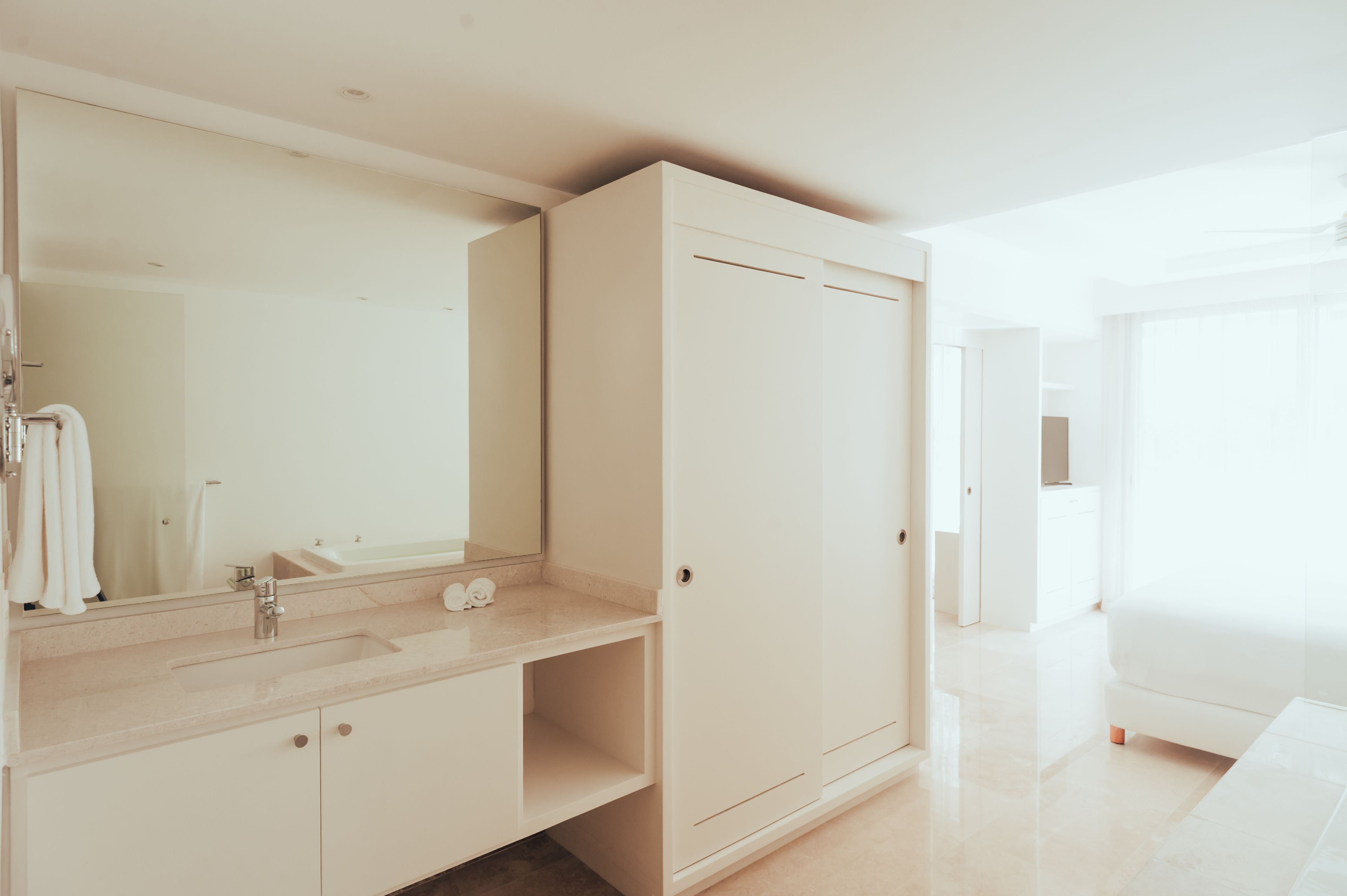 Un bagno moderno con uno specchio grande, un lavandino e un armadio.