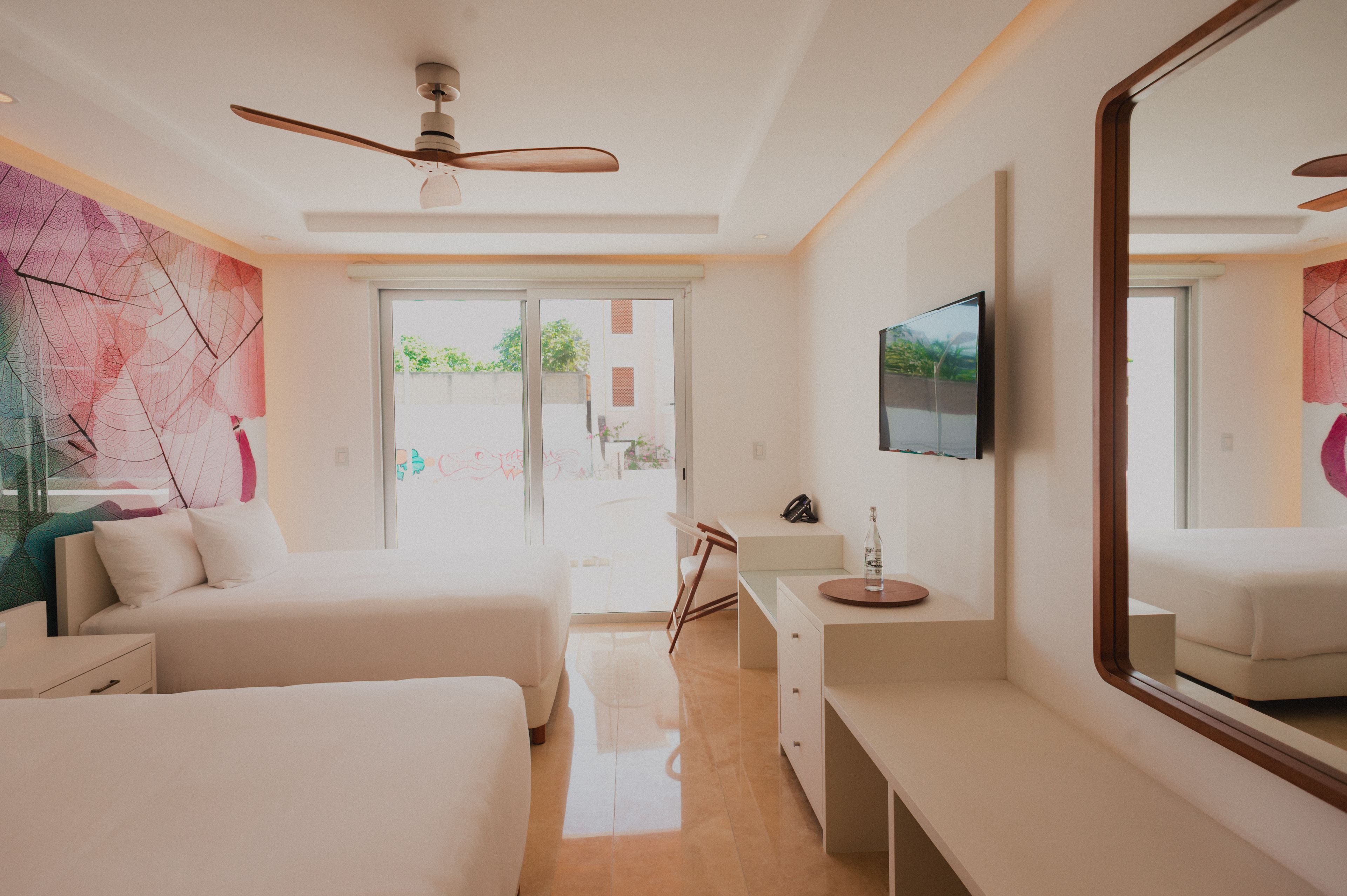 Une chambre d’hôtel moderne équipée d’un grand lit, d’un bureau, d’une chaise et d’un téléviseur.