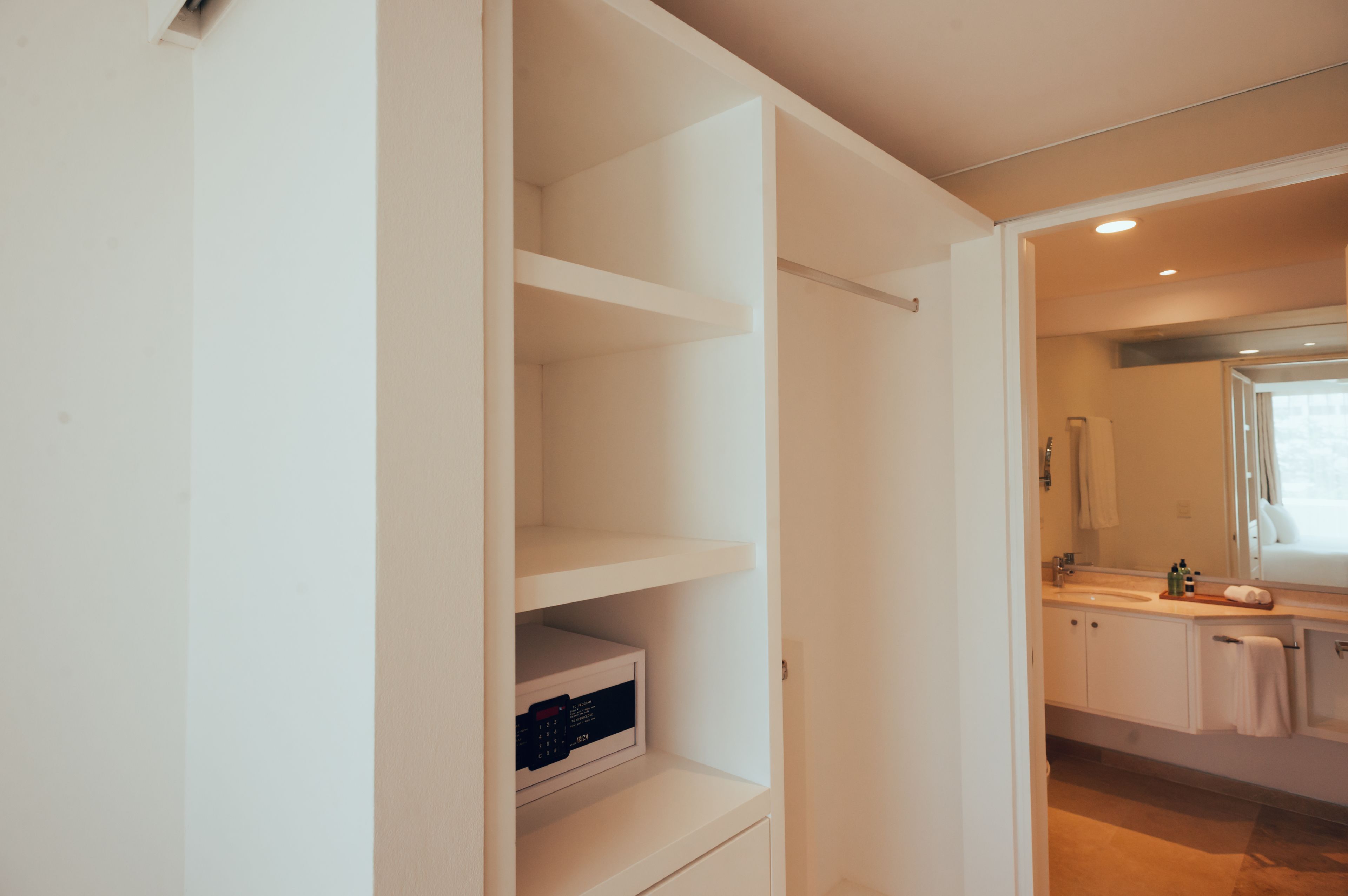 A modern bathroom with a built-in vanity, a mirror, and a shower area.