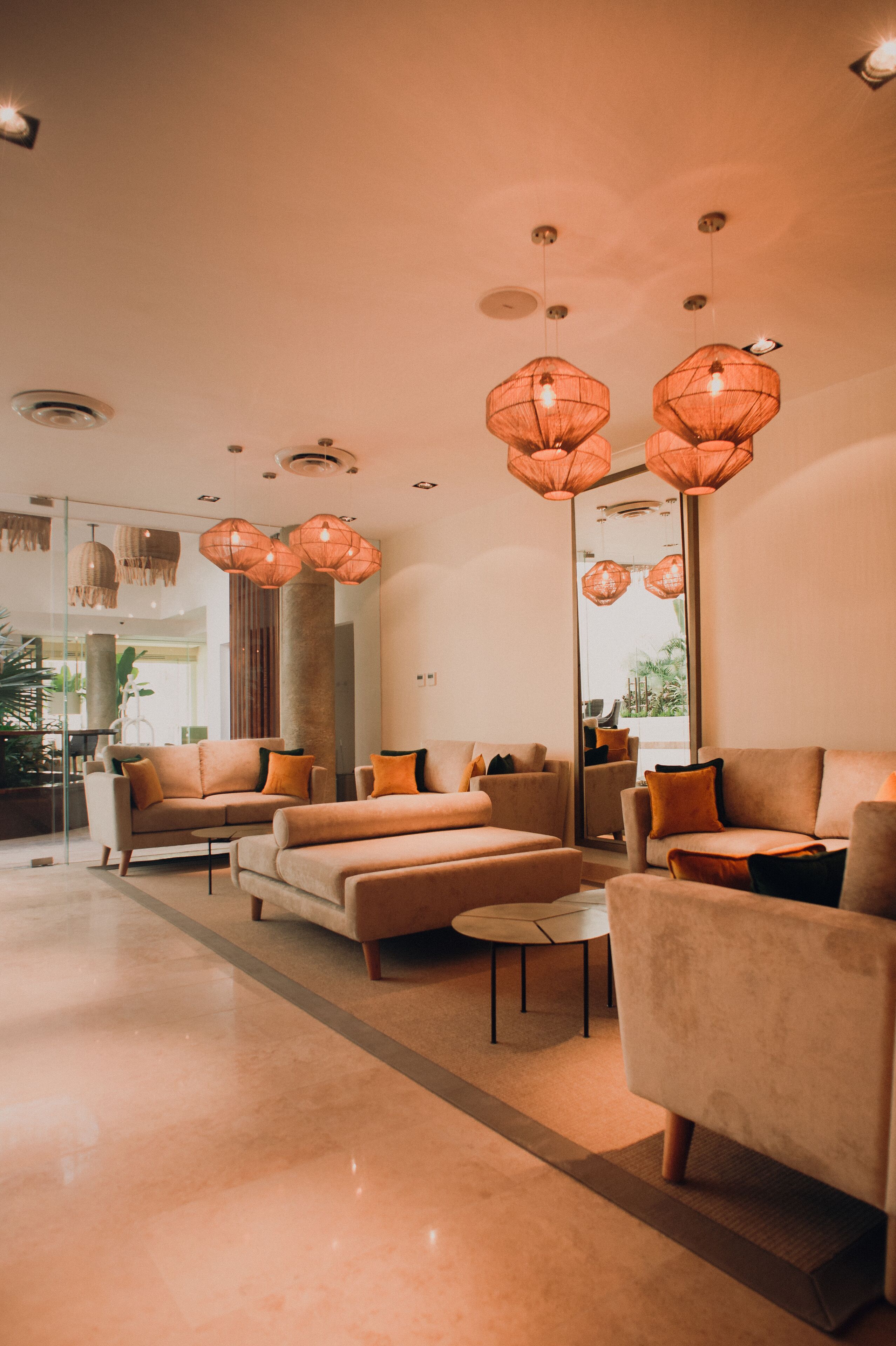 A modern living room with sofas, a coffee table, and pendant lights.