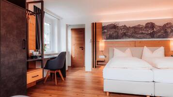 Ein modernes Schlafzimmer mit Bett, Schreibtisch, Stuhl und einem großen Gemälde an der Wand.
