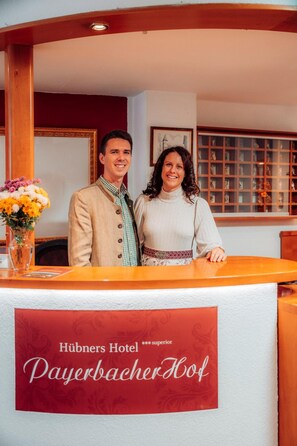 Un comptoir d’accueil à l’hôtel Hübners Payerbachhof, avec une enseigne indiquant son nom.