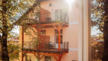 Ein mehrgeschossiges Gebäude mit Balkon, Holzbalken und einem Fenster.