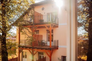 A multi-story building with a balcony, wooden beams, and a window.
