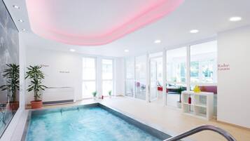 An indoor swimming pool with clear glass walls, potted plants, and a ceiling with a pink light.
