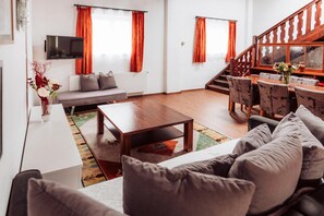Un salon moderne avec un canapé, une table basse et un coin repas avec des chaises.