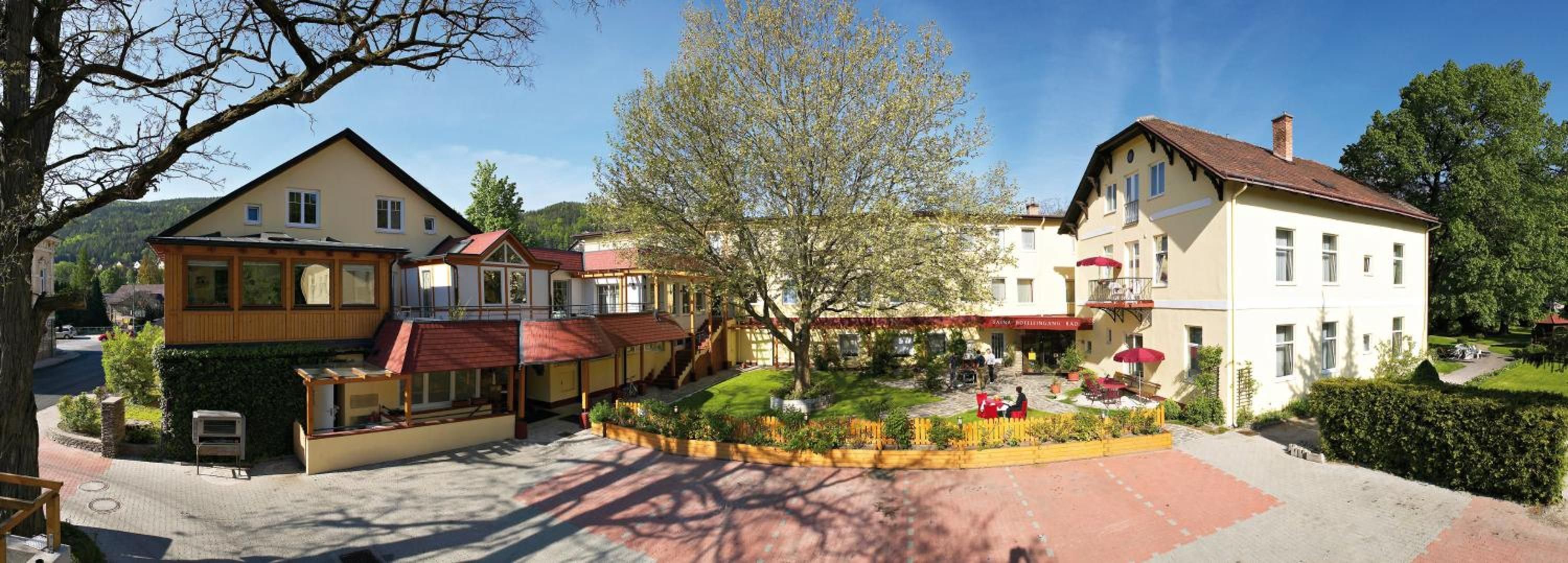 Ein Hotel mit Innenhof, mehreren Gebäuden und einer Bergkulisse.