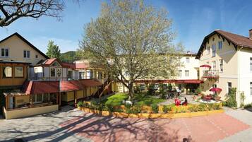 Ein Hotel mit Innenhof, mehreren Gebäuden und einer Bergkulisse.
