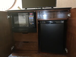 A compact kitchen with a microwave and a refrigerator built into a wooden cabinet. - Quality Inn & Suites Brainerd (Brainerd)