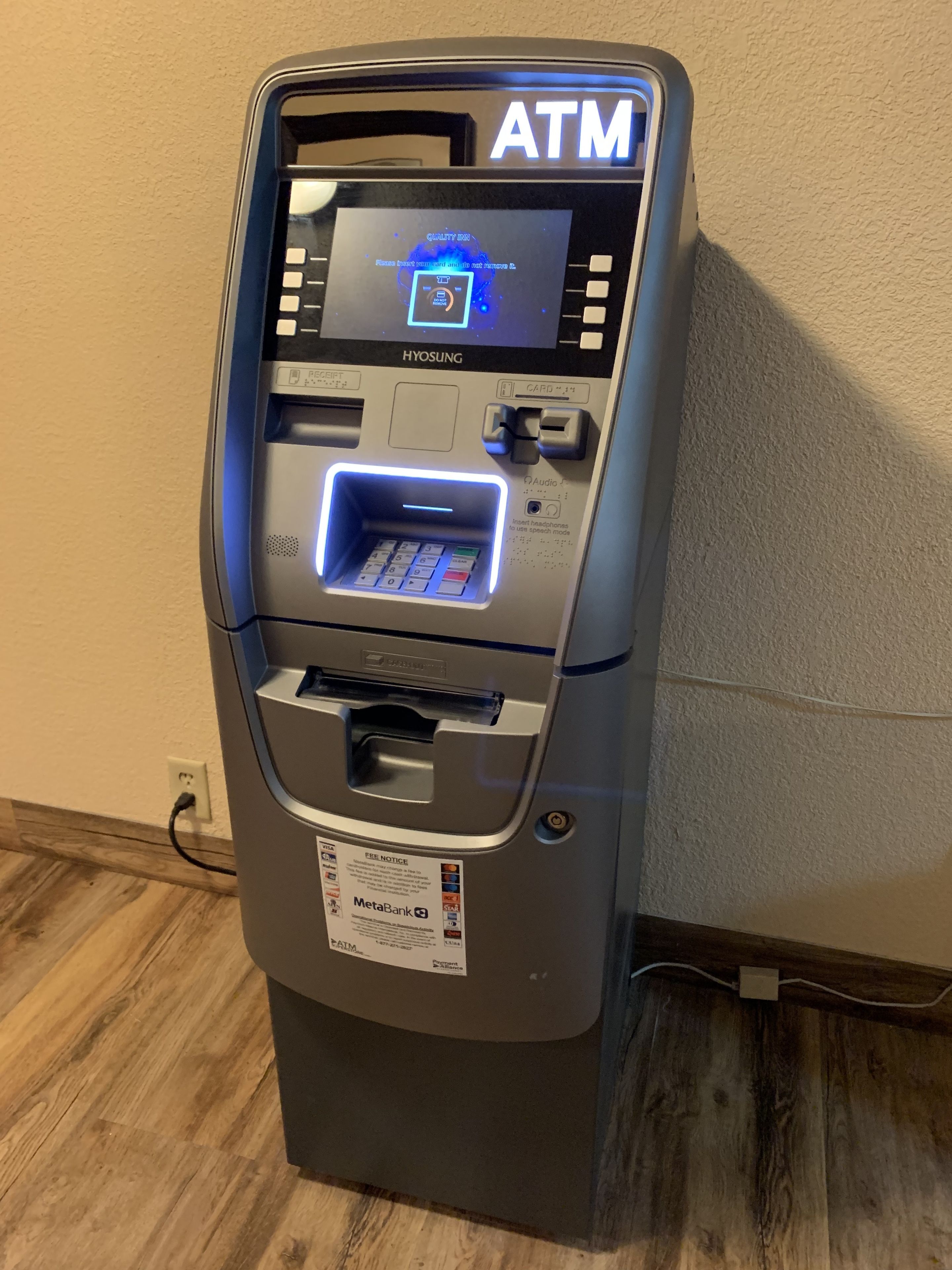 An ATM machine with a screen, card slot, and keypad.