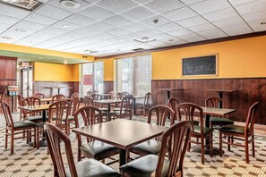 A restaurant with multiple tables and chairs, a chalkboard on the wall, and a tiled floor. - Quality Inn & Suites Brainerd (Brainerd)