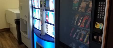 Un'area con distributori automatici, tra cui una macchina Pepsi e una vetrina refrigerata.