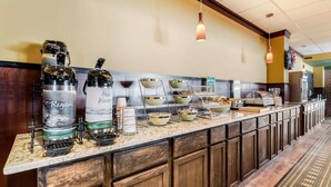 Montaje tipo buffet con varios dispensadores de bebidas, tazones y una barra.