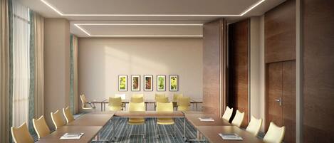 A conference room with a long table, yellow chairs, and framed pictures on the wall.