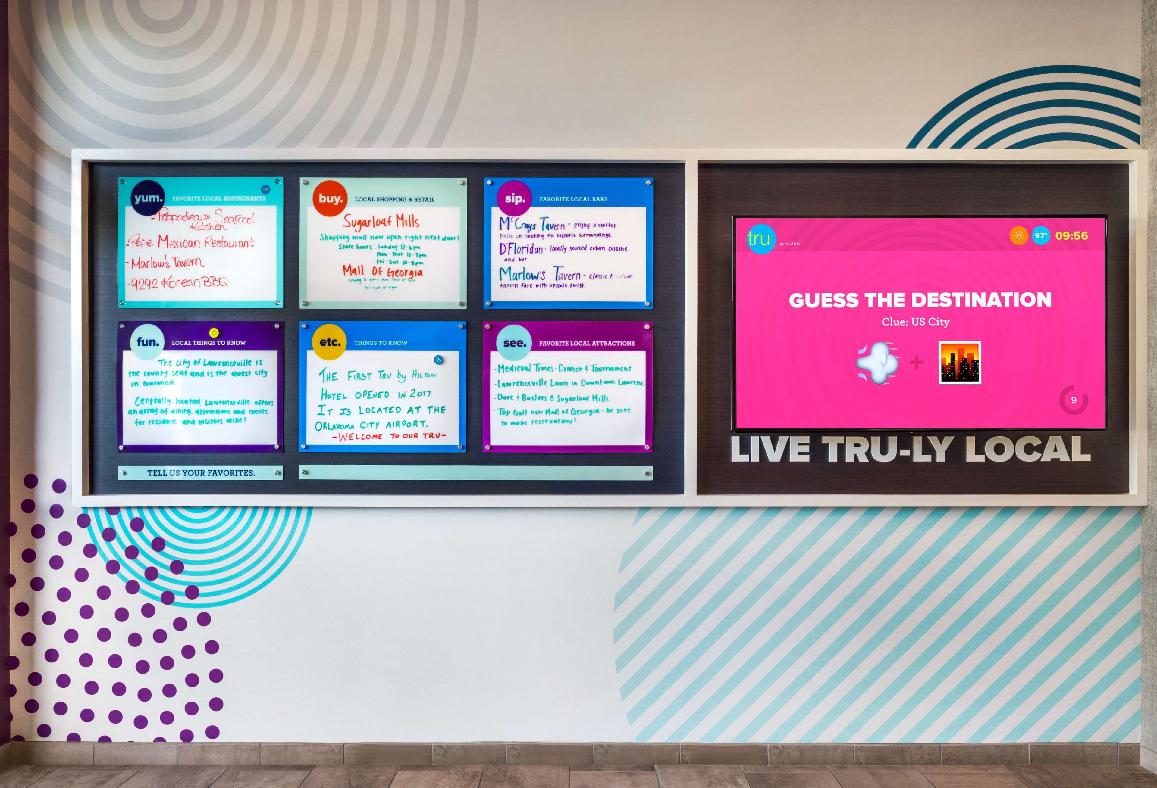 Una pared con varios paneles informativos y una pantalla de transmisión en vivo.