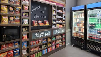 A snack display with Lay's and Doritos, a chalkboard sign, and a refrigerated drink cooler.