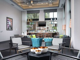 A modern living room with a sofa set, a coffee table with bowls, and a kitchen area with a bar.
