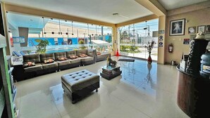 Eine geräumige Lobby mit einer Sitzecke, einem Empfangstresen und großen Fenstern mit Blick nach außen.