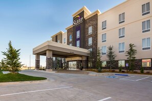 A Sleep Inn & Suites building with a modern design, featuring a covered entrance and a parking lot with handicapped parking.