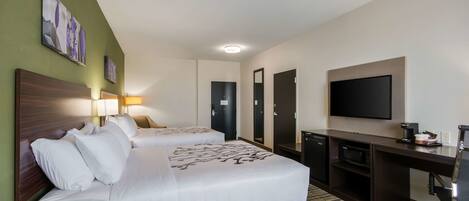 Habitación de hotel con dos camas, un escritorio, televisor y microondas.