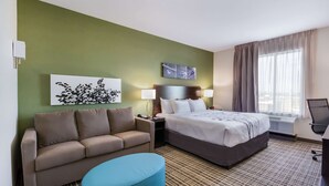 A hotel room with a bed, a sofa, a desk, and a chair. - Sleep Inn & Suites Yukon Oklahoma City (Yukon)
