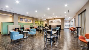 A spacious indoor area with multiple seating arrangements, including sofas and chairs, and a long counter with tables. - Sleep Inn & Suites Yukon Oklahoma City (Yukon)