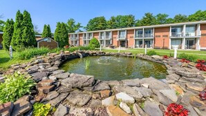 A building with a pond surrounded by rocks and plants, and a small shed in the background. - AIRE Hotel Hershey Lebanon (Lebanon)