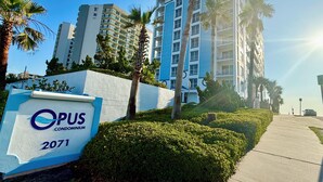 Opus Condominium 2071 -niminen kyltti, taustalla moderni rakennus.