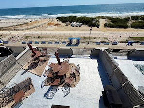 Terraço no telhado com área de estar externa, piscina e vista para a praia e o oceano.
