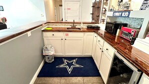 A kitchen with white cabinets, a wooden countertop, a Star Wars-themed rug, and a microwave. - Hatteras Hideaway - Perfect for wanting to enjoy all that Columbia has to offer. (Columbia)
