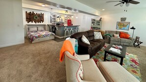 A living room with a sofa, armchairs, a coffee table, and a dining area with bar stools. - Hatteras Hideaway - Perfect for wanting to enjoy all that Columbia has to offer. (Columbia)