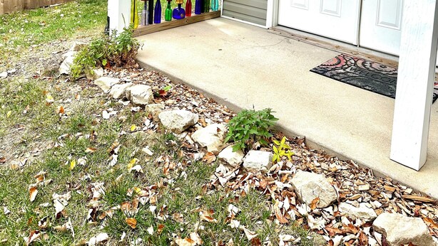 A house entrance with a colorful glass door, a white garage door, and a concrete driveway with a doormat. - Hatteras Hideaway - Perfect for wanting to enjoy all that Columbia has to offer. (Columbia)